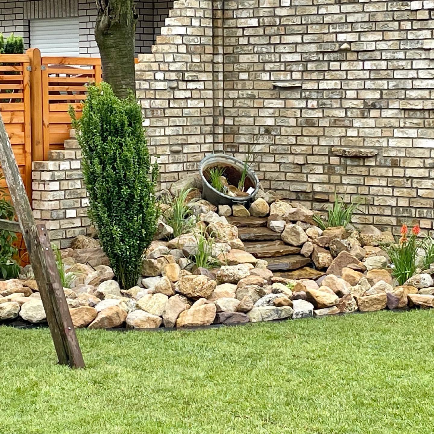 Kleiner dekorativer Gartenbrunnen, der dem Garten eine stilvolle und beruhigende Atmosphäre verleiht.